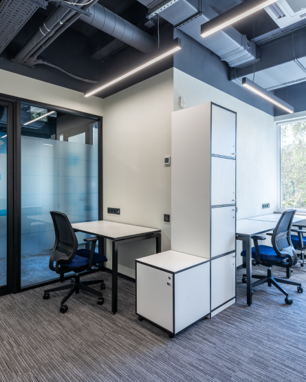 Oficina moderna con escritorios, sillas ergonómicas y lockers, ideal para desarrolladores y equipos de diseño web en Querétaro.